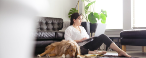 woman sitting at home with her dog looking for a job