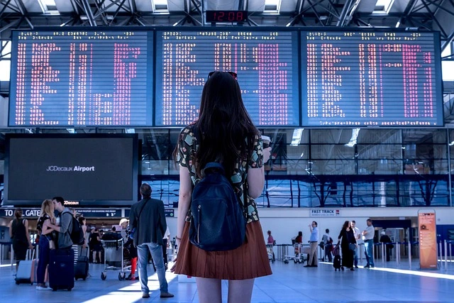 female traveler looking at the schedule in a busy airport