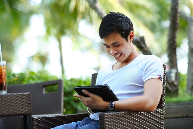 man-looking-at-his-portfolio-on-a-tablet-and-smiling