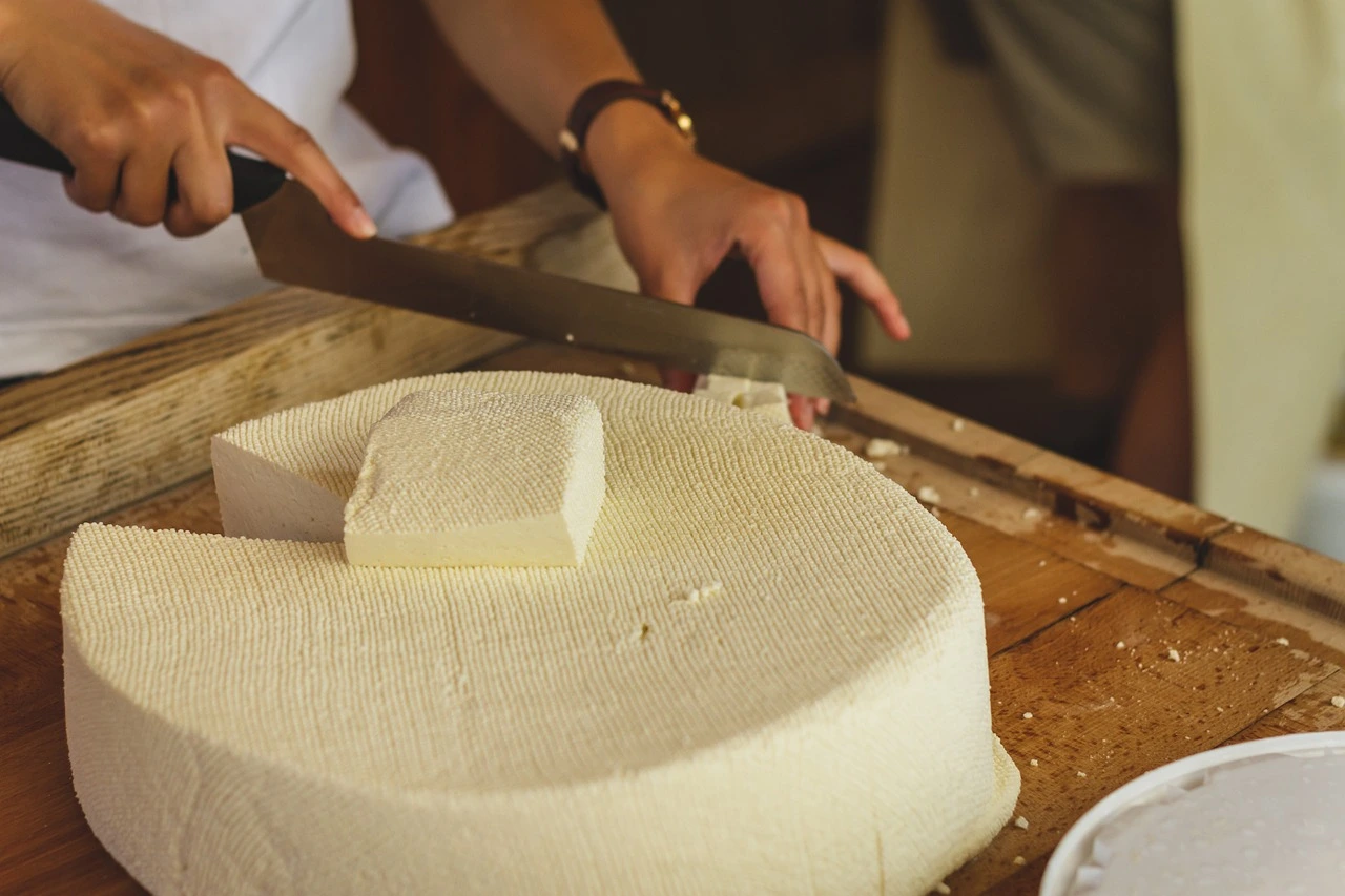 Cheese maker working with a raw block of cheese