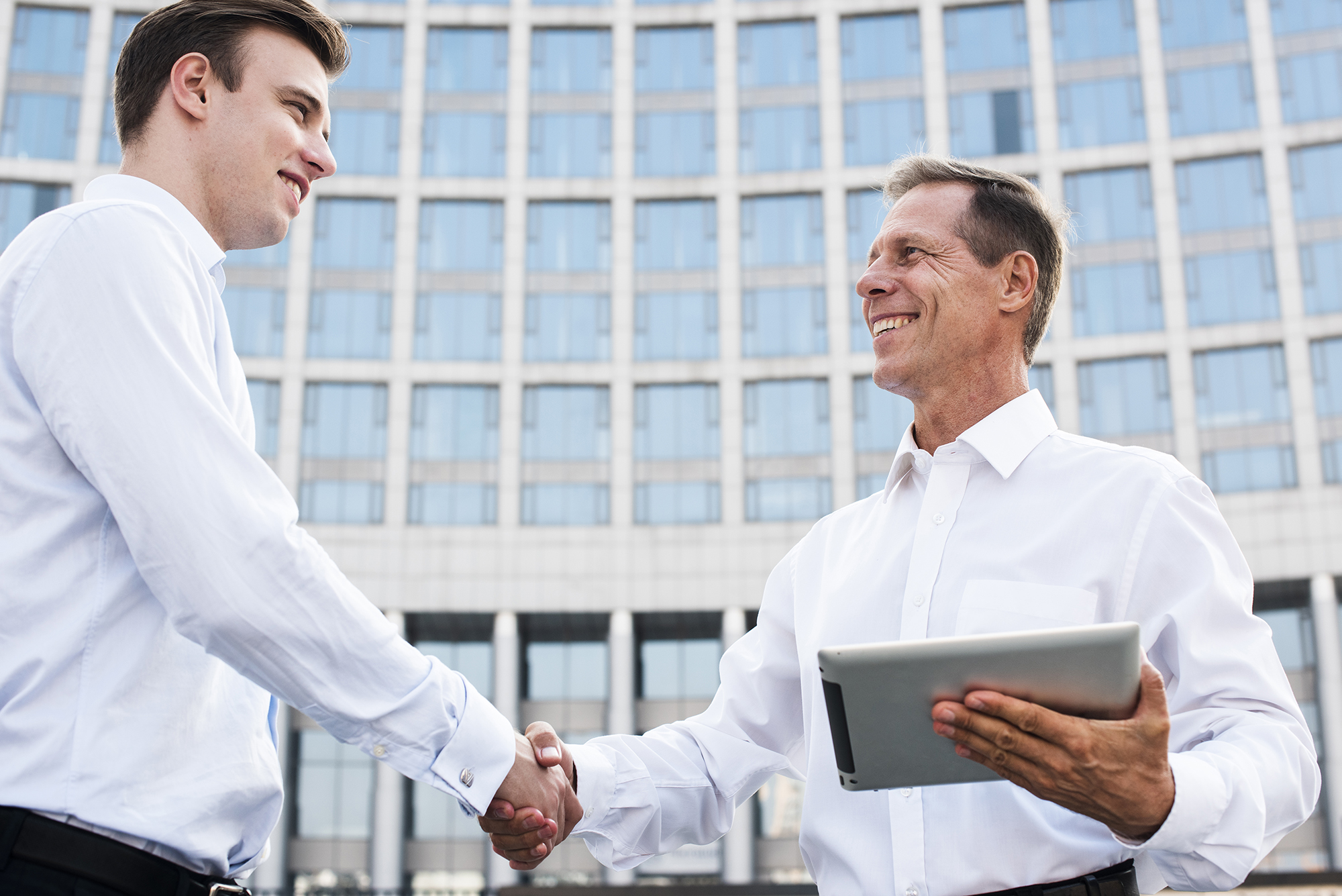 businessmen-shaking-hands-near-building
